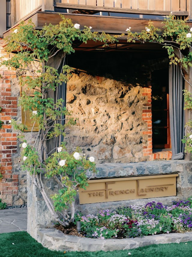 The restaurant's stone facade under climbing roses