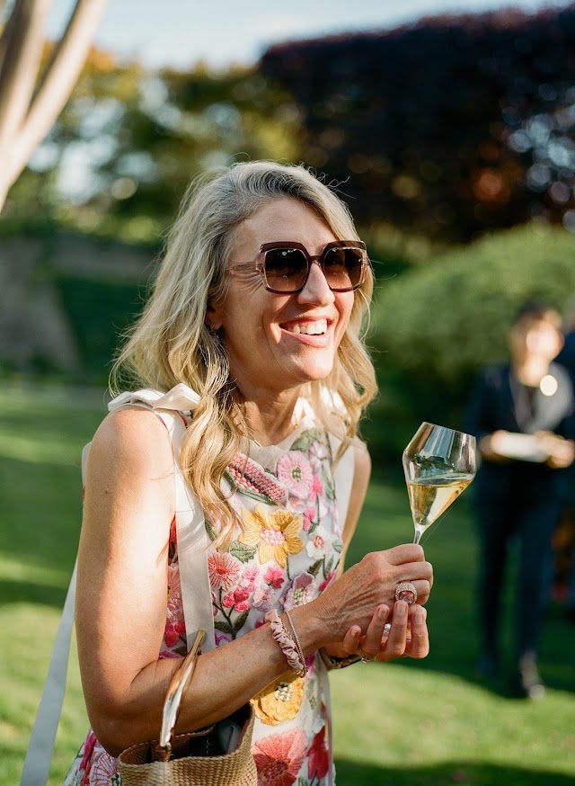 A guest laughing with a glass of Champagne